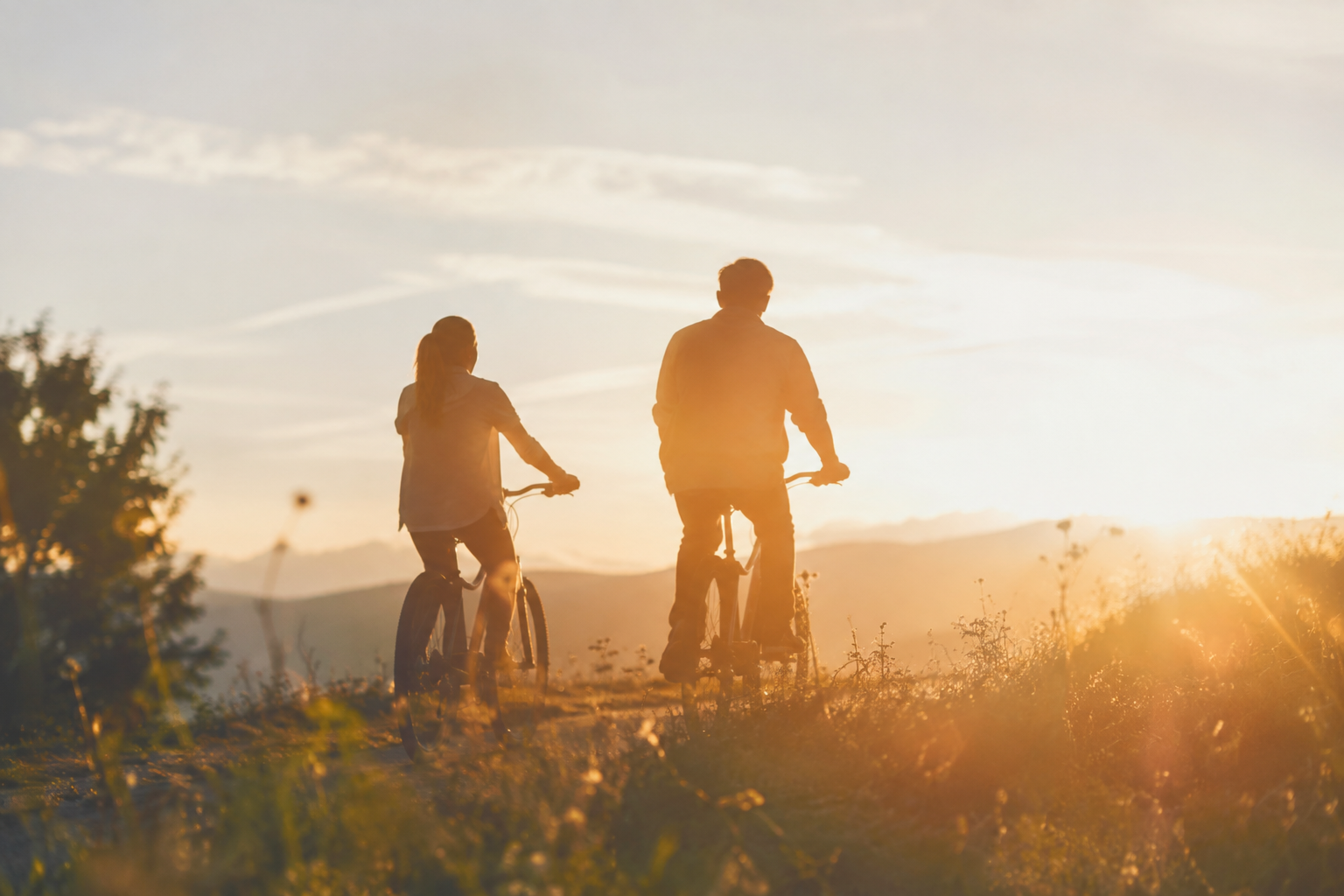Una pareja paseando en bicicleta por un sendero hacia el horizonte